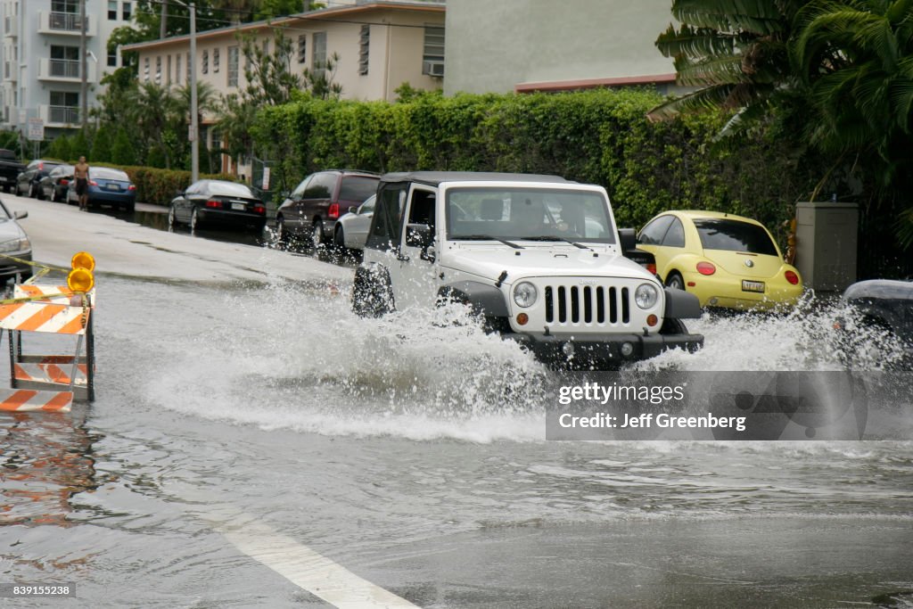A Jeep driving through a flooded Alton Road.