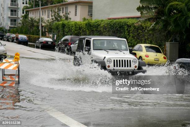 Jeep driving through a flooded Alton Road.