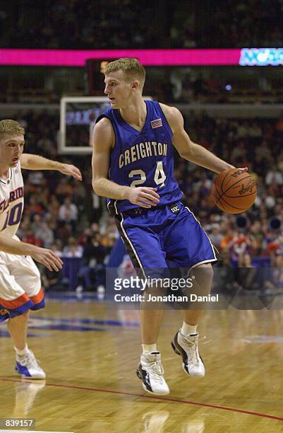Guard Tyler McKinney of the Creighton Bluejays dribbles the ball on the perimeter against guard Brett Nelson of the Florida Gators during the first...