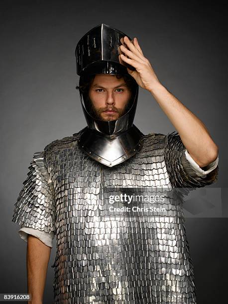 male knight tipping helmet - knight person stock pictures, royalty-free photos & images