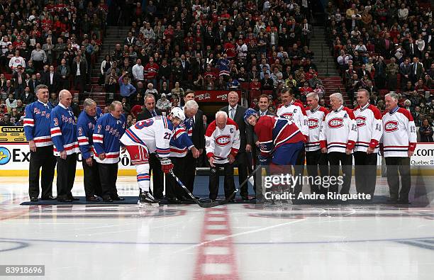 Henri Richard and other former greats of the New York Rangers and Montreal Canadiens drop the puck for a ceremonial faceoff with Saku Koivu of the...