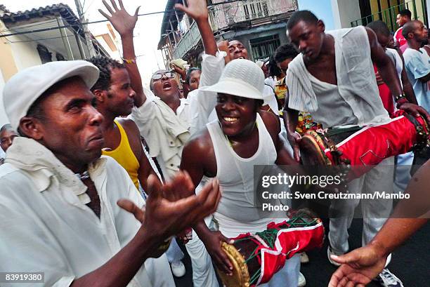 Cubans play instruments and clap as they walk in a procession of people where a statue of Saint Barbara is carried in celebration of the anniversary...