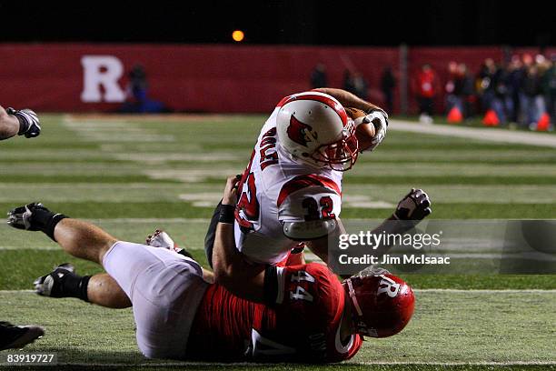 Brock Bolen of the Louisville Cardinals runs in a fourth quarter touchdown against Ryan D'Imperio of the Rugers Scarlet Knights at Rutgers Stadium on...