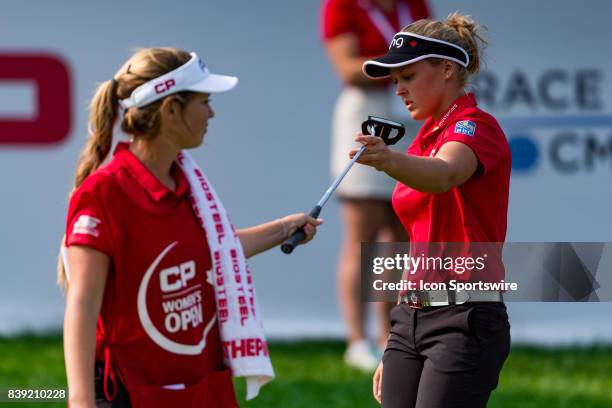 Brooke Henderson hands her putter off to caddie/sister Brittany Henderson during the second round of the Canadian Pacific Women's Open on August 25,...