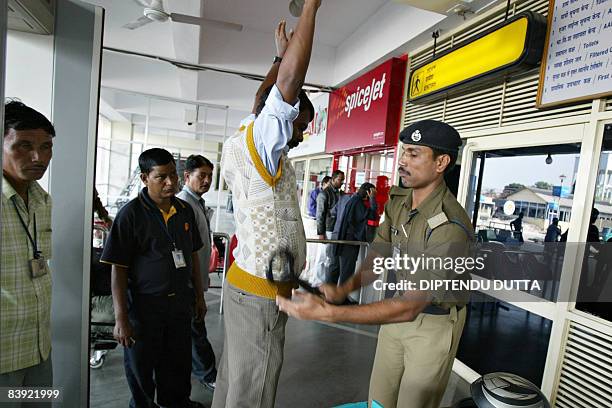 An Indian Central Industrial Security Force officer frisks a passenger at a security checkpoint in Bagdogra airport, on the outskirts of Siliguri, on...