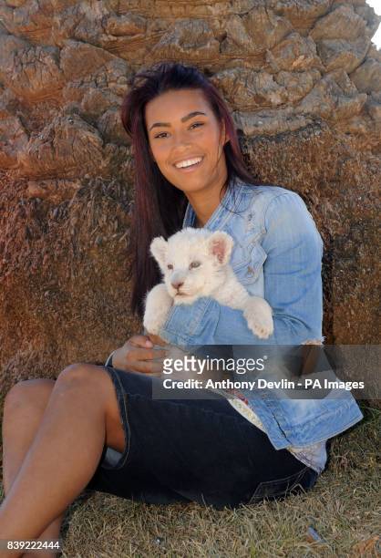 Chantelle Tagoe poses with a 6-week-old white lion cub called Acinony during a visit to the Cheetah Experience in Bloemfontein, South Africa.