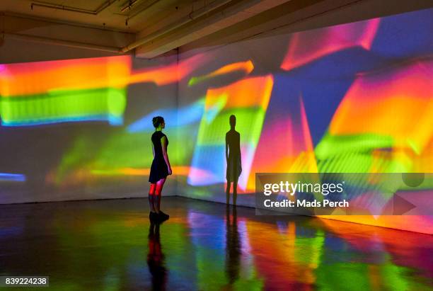 girl looking at a large scale image of projected patterns - imagine there stock pictures, royalty-free photos & images