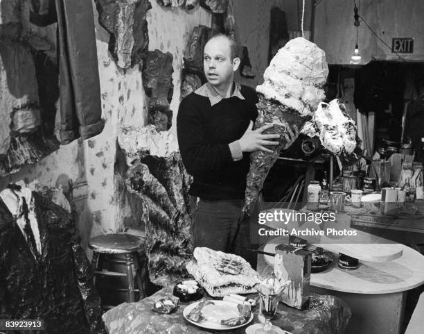 Swedish-born American artist Claes Oldenburg holds one of his pieces, a four-foot ice cream cone, at his studio in Greenwich Village, New York City,...