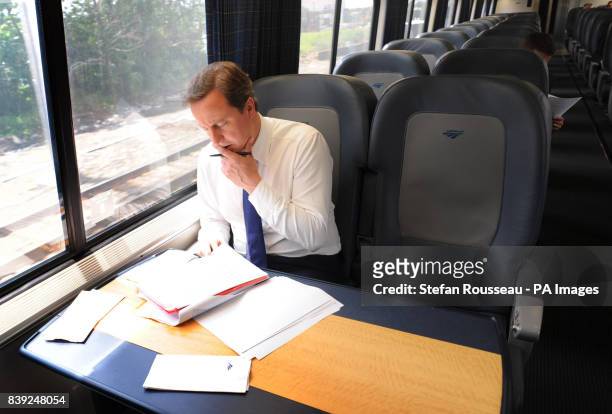 Britain's Prime Minister David Cameron works onboard the Acela Express from Wasington DC, Washington, to New York's Penn Station, as part of his two...