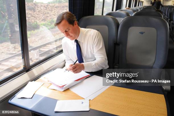 Britain's Prime Minister David Cameron works onboard the Acela Express from Wasington DC, Washington, to New York's Penn Station, as part of his two...