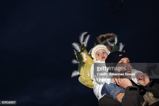 Father carries his daughter, dressed as Christmas angel near the Neuburg Christmas market on December 5, 2008 in Neuburg an der Donau, Germany. With...
