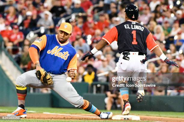 New York Mets first baseman Dominic Smith cannot handle a low throw allowing Washington Nationals shortstop Wilmer Difo during an MLB game between...