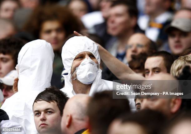 Leeds United fan wearing a dust mask in the stands.