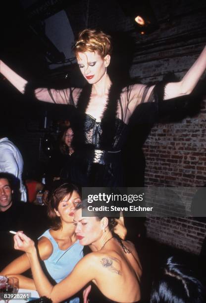 Kristen McMenamy stands above Helena Christiansen and Carre Otis at a table in The Tunnel nightclub during the Venus of Fashion Awards, 1994.