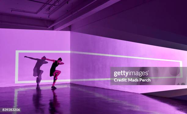 girl dancing in an abstract space with graphics shapes projected behind her - projection mapping stock pictures, royalty-free photos & images