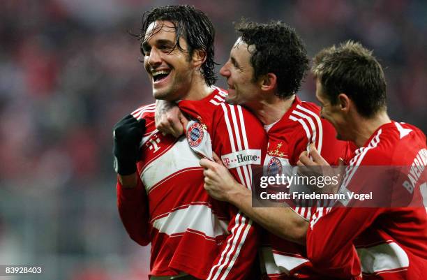 Luca Toni of Bayern celebrates after scoring the winning goal with Mark van Bommel and Miroslav Klose during the Bundesliga match between Bayern...