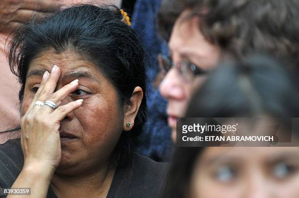 Woman reacts next to a house where five people where found dead in Guatemala City on December 5, 2008. Five members of the same family, including...