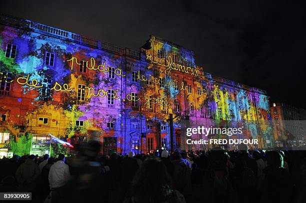 People watch a light show on December 5, 2008 in Lyon, central eastern France, as part of the 10th edition of the "Fete des lumieres" , the secular...