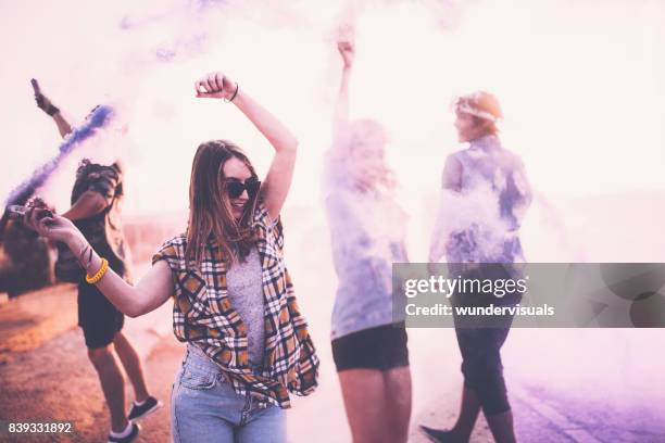 teenage friends having fun with smoke bombs in city streets - guy girl street laugh stock pictures, royalty-free photos & images