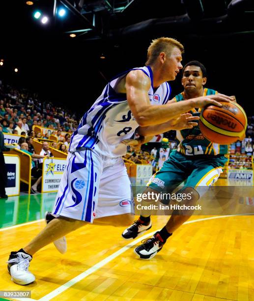 Clint Reed of the Spirit looks to get past Michael Cedar of the Crococdiles during the round 12 NBL match between the Townsville Crocodiles and the...