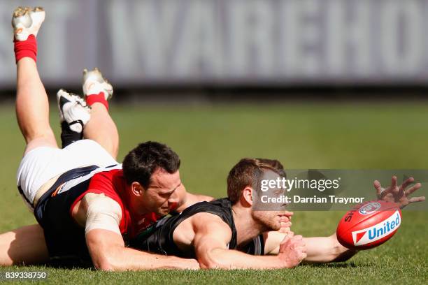 Cameron Pedersen of the Demons tackles Matt Scharenberg of the Magpies during the round 23 AFL match between the Collingwood Magpies and the...