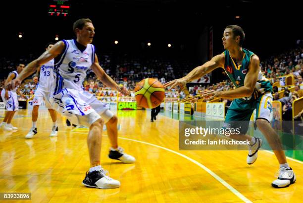 Anthony Susnjara of the Crocodiles s gets a pass away past Graeme Dann of the Spirit during the round 12 NBL match between the Townsville Crocodiles...