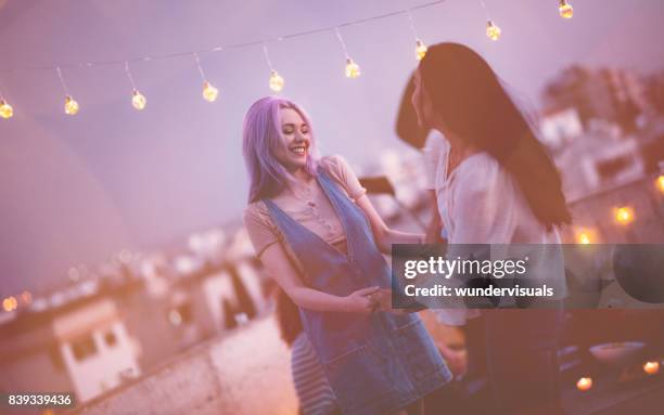 amigas de la joven inconformista bailando en fiesta de verano urbano en la azotea - una sola mujer joven fotografías e imágenes de stock