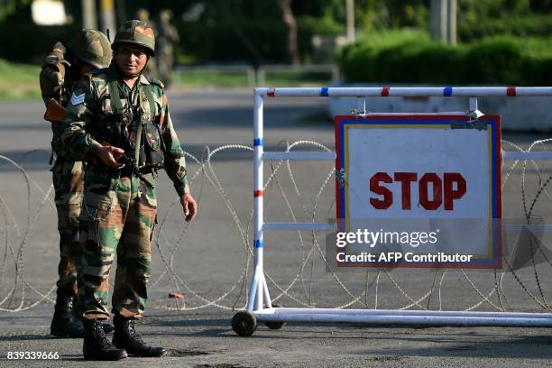 Indian soldiers stand guard at a checkpoint at Panchkula on August 26 after followers of controversial guru Ram Rahim Singh on August 25 went on a...