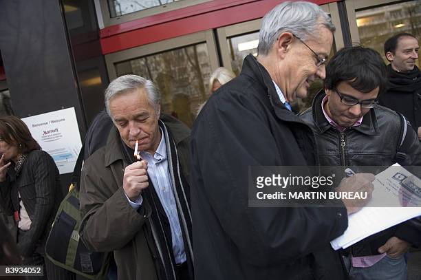 French Socialist senator Francois Rebsamen lights a cigarette, as Socialist deputy Jean-Louis Bianco signs a petition as they arrive for the...