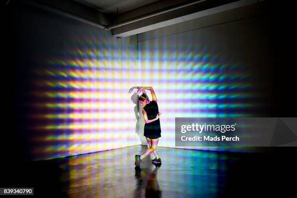 girl dancing in a studio with graphic patterns projected onto her - projection mapping stock pictures, royalty-free photos & images