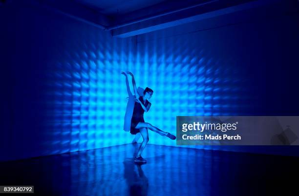 girl dancing in a studio with graphic patterns projected onto her - performance fotografías e imágenes de stock