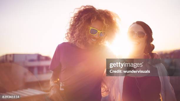 hipster friends with drinks laughing at summer rooftop party - rooftop party stock pictures, royalty-free photos & images