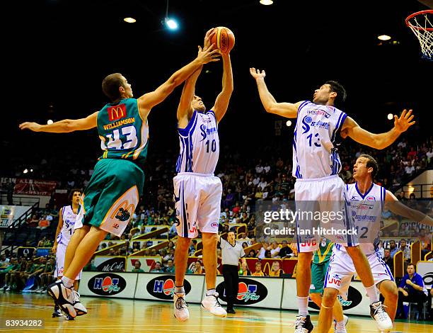 Jason Smith of the Spirit makes a jump shot despite the defence of Brad Williamson of the Crocs during the round 12 NBL match between the Townsville...