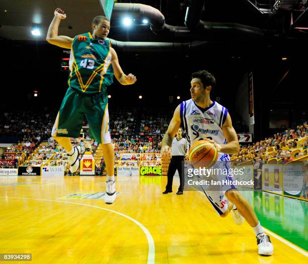 Liam Rush of the Spirit looks to gget past a leaping Brad Williamson of the Crocs during the round 12 NBL match between the Townsville Crocodiles and...