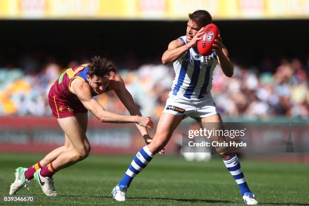 Andrew Swallow of the Kangaroos is tackled during the round 23 AFL match between the Brisbane Lions and the North Melbourne Kangaroos at The Gabba on...