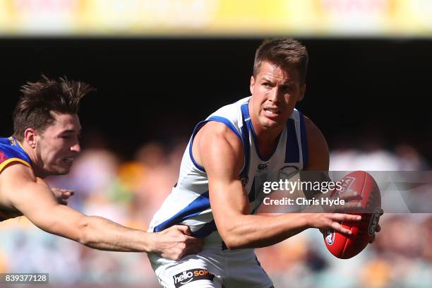 Andrew Swallow of the Kangaroos is tackled during the round 23 AFL match between the Brisbane Lions and the North Melbourne Kangaroos at The Gabba on...