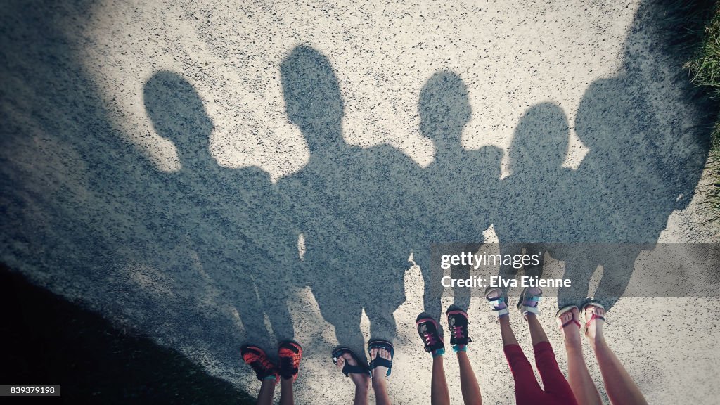 Shadows on a gravel path of a family of five