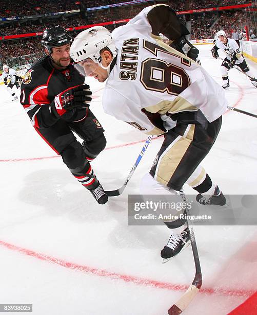 Jason Smith of the Ottawa Senators defends against Miroslav Satan of the Pittsburgh Penguins in the corner at Scotiabank Place on December 6, 2008 in...