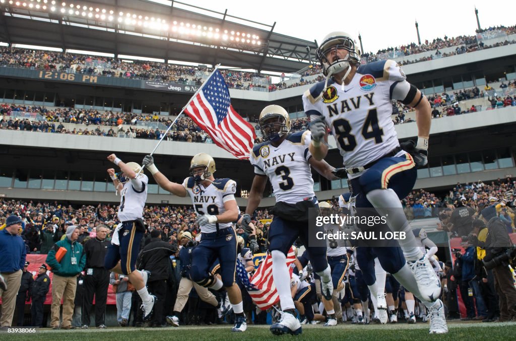 Members of the Navy football team run ou