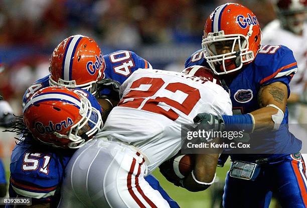 Brandon Spikes, Brandon Hicks and Joe Haden of the Florida Gators tackle running back Mark Ingram of the Alabama Crimson Tide during the SEC...