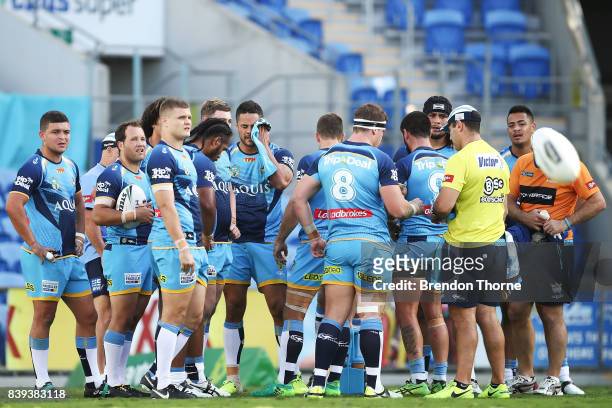 Jarryd Hayne of the Titans wipes his face as the rest of the team look on after conceding a try during the round 25 NRL match between the Gold Coast...
