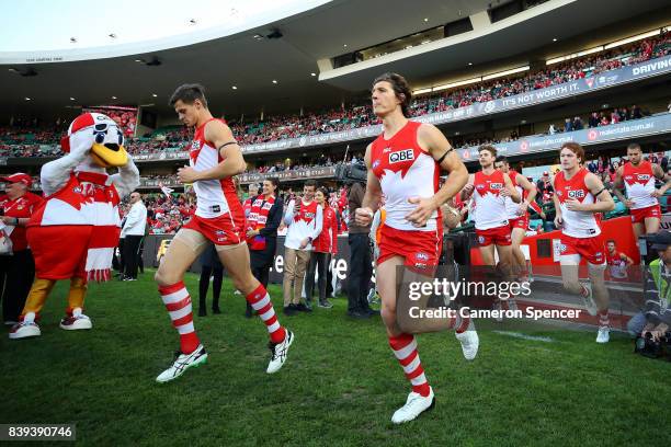 Callum Sinclair of the Swans and Kurt Tippett of the Swans run onto the field during the round 23 AFL match between the Sydney Swans and the Carlton...