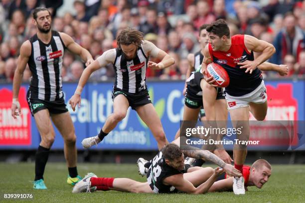 Christian Petracca of the Demons leaps over team mate during the round 23 AFL match between the Collingwood Magpies and the Melbourne Demons at...