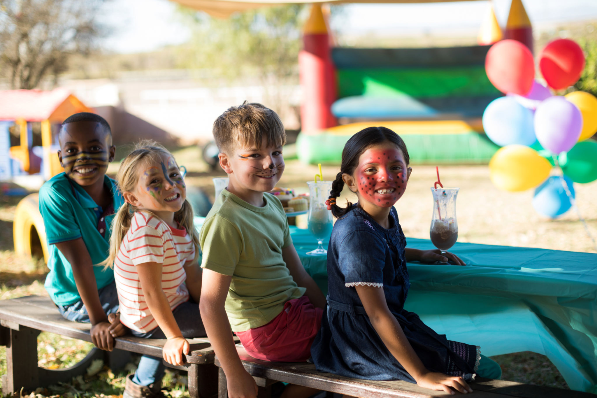 Children with face paint laughing at My Learning Odyssey