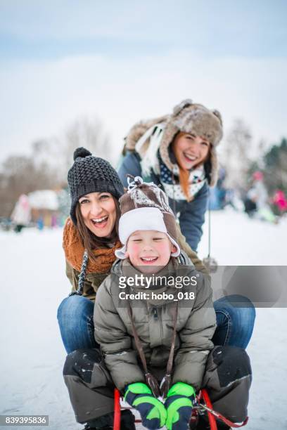 winterspaß - rodeln im winter - family in snow mountain stock-fotos und bilder