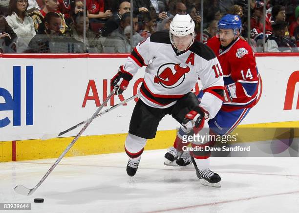 John Madden of the New Jersey Devils carries the puck as he is chased by Tomas Plekanec of the Montreal Canadiens during their NHL game at the Bell...