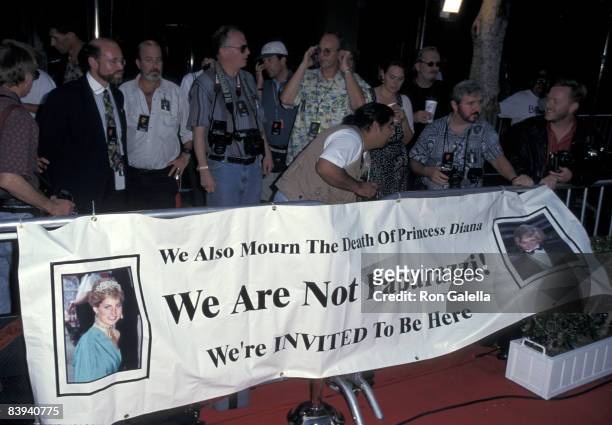The press hold a sign stating "We also mourn the death of Princess Diana. We are not paparazzi. We're invited to be here."