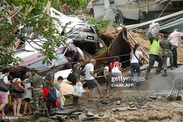 Rescue workers help survivors evacuate after a landslide in a residential area in Kuala Lumpur on December 7, 2008. Malaysia's prime minister...