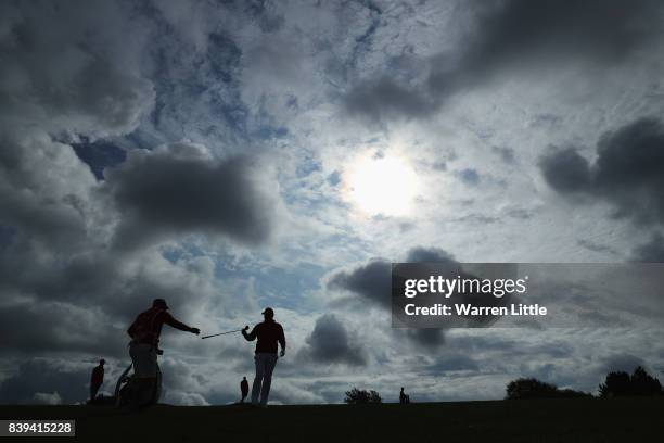 Thomas Bjorn of Denmark gives a club to his caddie on the 11th hole during day three of the Made in Denmark at Himmerland Golf & Spa Resort on August...