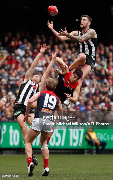 Jeremy Howe of the Magpies takes a spectacular mark over Christian Petracca of the Demons during the 2017 AFL round 23 match between the Collingwood...